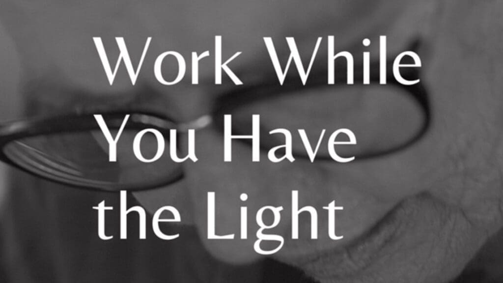 Black and white close-up of older person in glasses with text "Work while you have the light" over the image