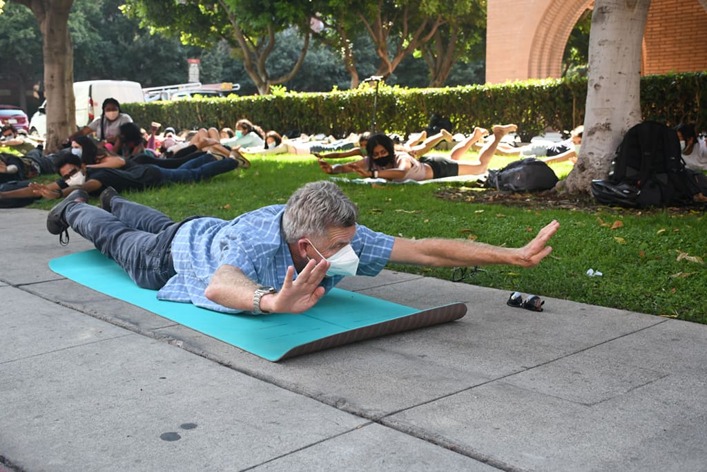 Associate Professor John Walsh leads his Gerontology 310 class in a yoga and core strength routine in front of the Andrus Gerontology Center