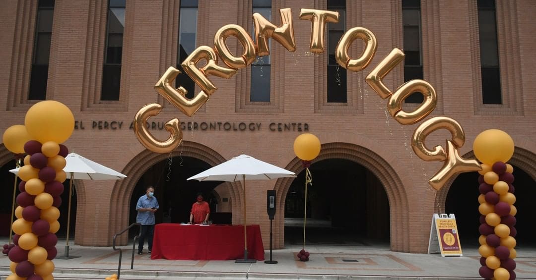 Photo of balloons spelling out "Gerontology" in front of the school building on orientation day