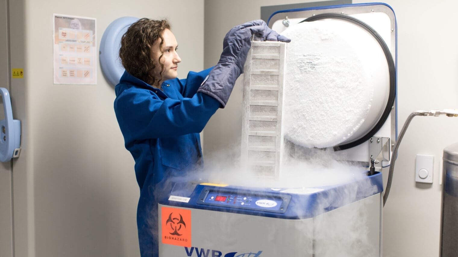 Scientist taking something out of lab container emitting fog
