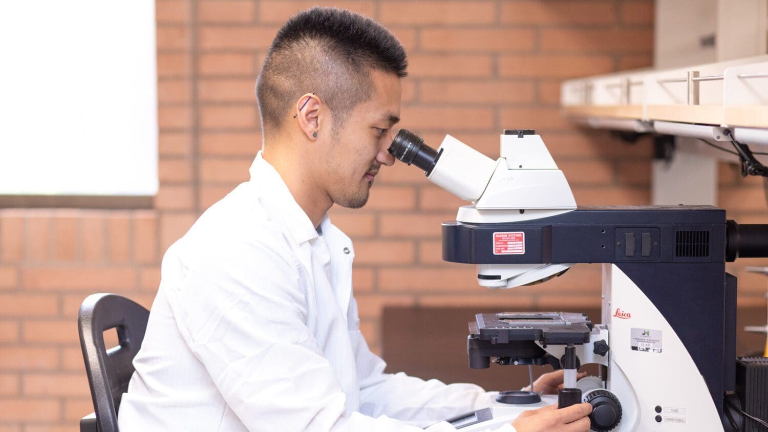 Ryo Sanabria looking into microscope