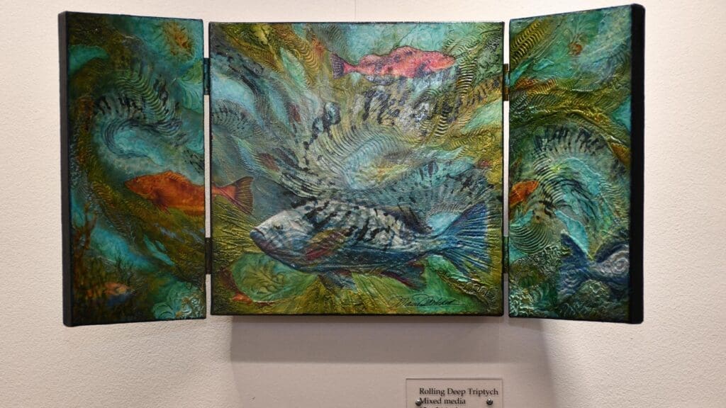 Wall exhibit with three panels showing artwork of fish