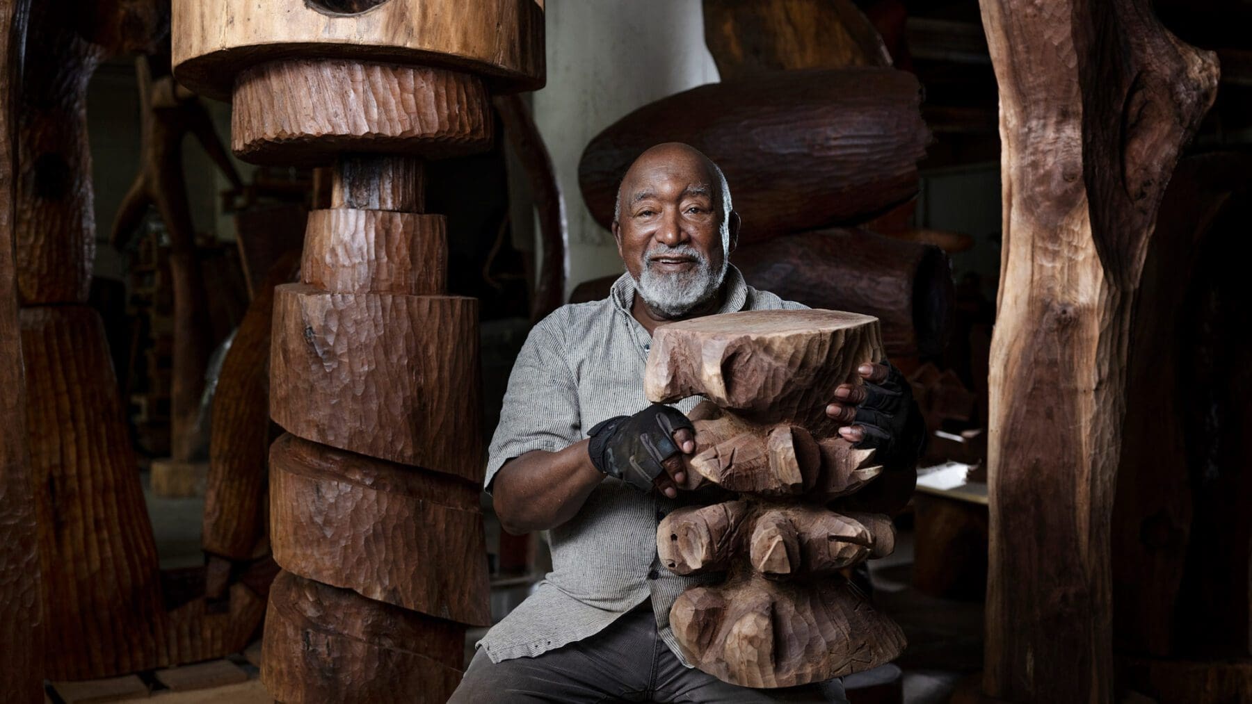 Thad Mosley holding his wooden sculpture in his art studio