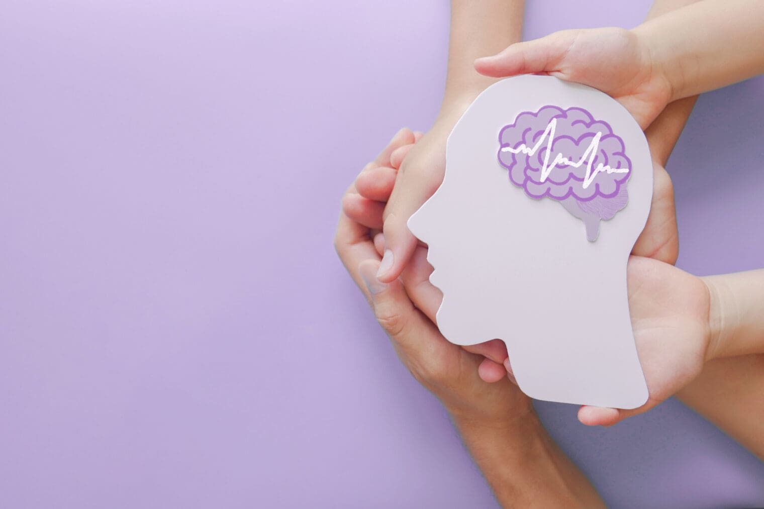 Adult and child hands holding encephalography brain paper cutout