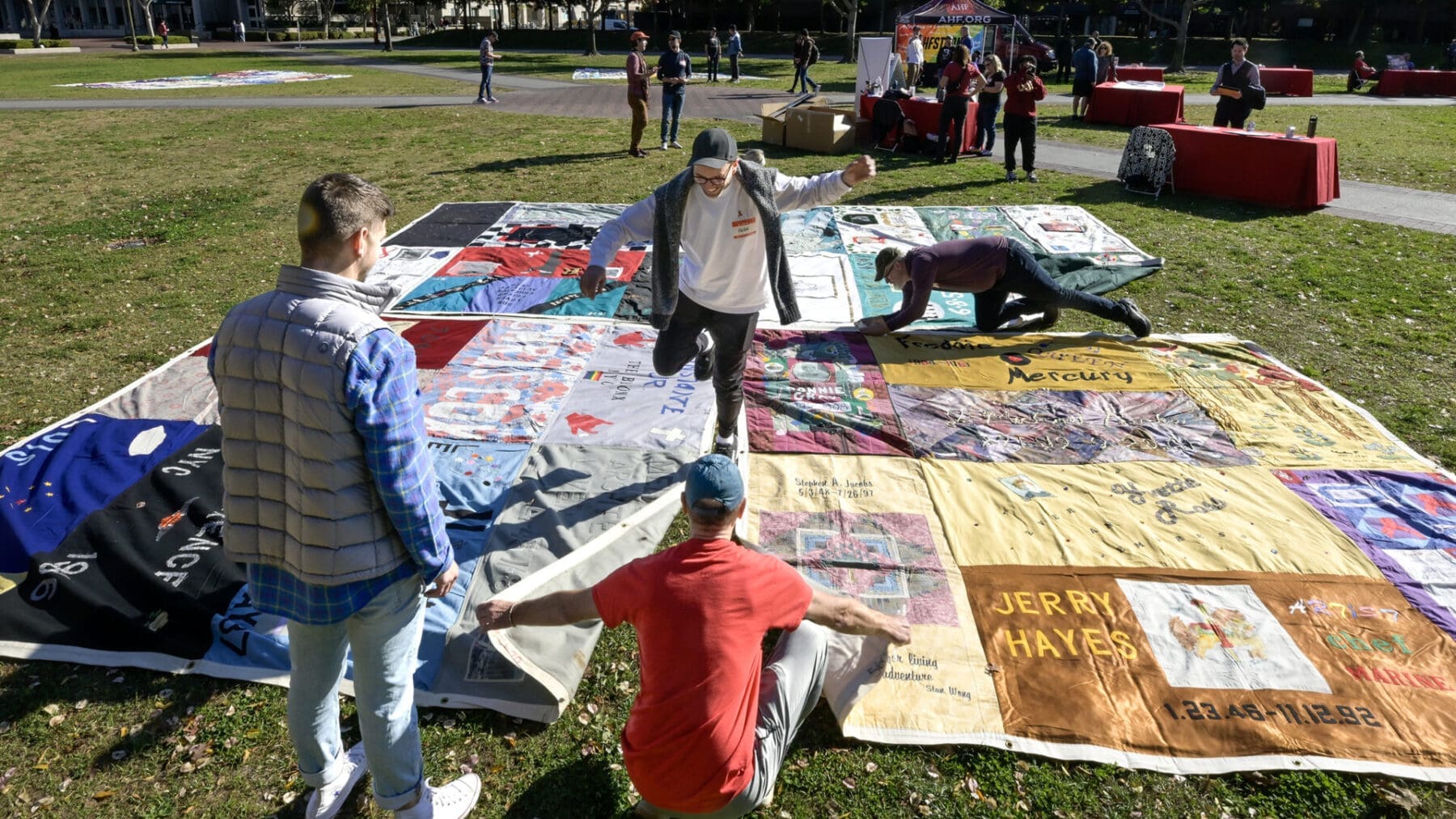 Workers and volunteers assemble sections of the AIDS Quilt out on McCarthy quad during AIDS quilt memorial and life celebration for World AIDS Day, Dec. 1, 2023. (Photo/Gus Ruelas)