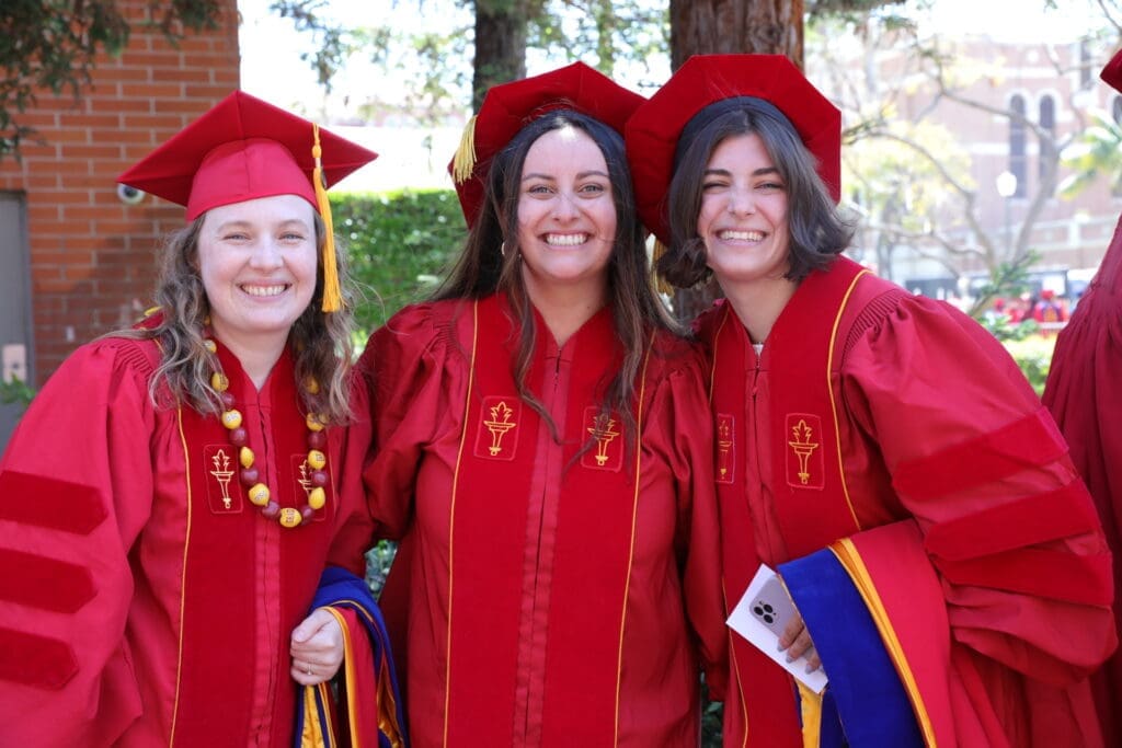 Three students in PhD robes at USC Leonard Davis School of Gerontology Commencement 2024