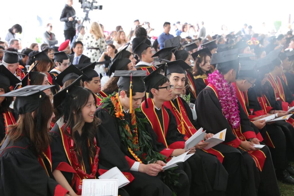 Students seated with ceremony pamphlets at the USC Leonard Davis School of Gerontology Commencement 2024
