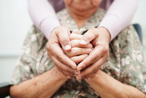 Caregiver holding hands elderly woman patient