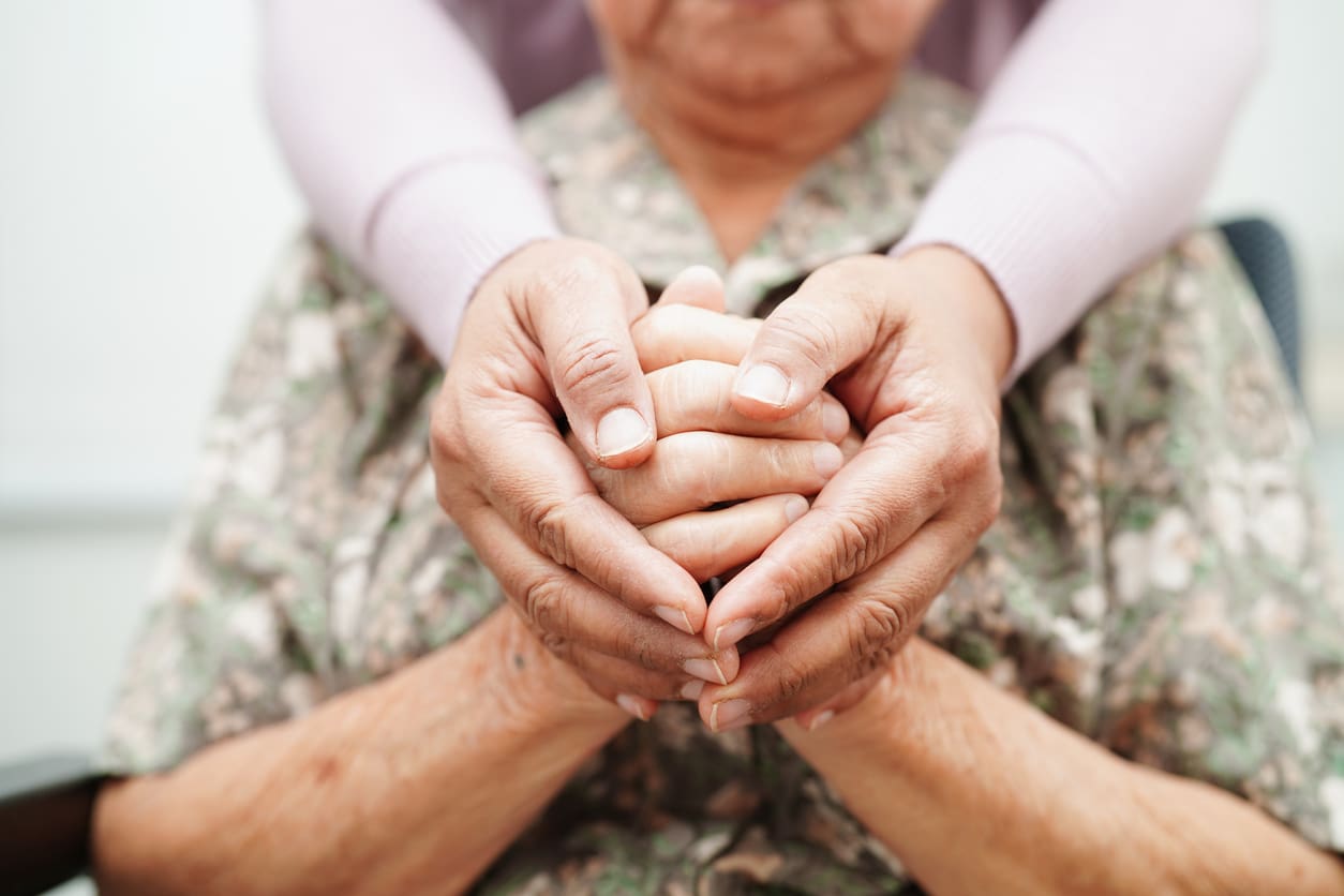 Caregiver holding hands elderly woman patient