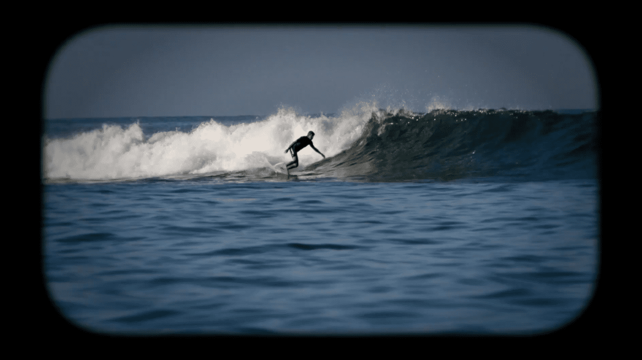 Still of Associate Professor John Walsh surfing